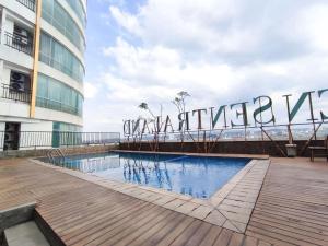 a swimming pool in front of a building at Homey and Strategic Studio (No Kitchen) at Sentraland Semarang Apartment By Travelio in Semarang
