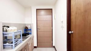 PampangにあるCompact Studio Room Apartment Vida View Makassar By Travelioのキッチン(シンク付)、木製のドア