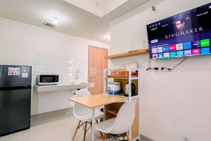 PatjinongongにあるCozy 1BR (No Kitchen) at Bandaraya - Tallasa City Makassar Apartment By Travelioのキッチン(テーブル、黒い冷蔵庫付)