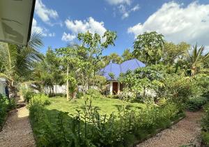 a garden with a house in the background at Cozy private villa in Fukuchani in Mchangani