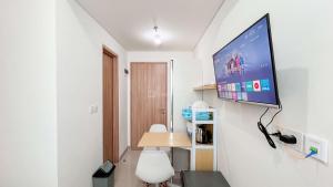 a room with a flat screen tv on the wall at Tranquil Studio (No Kitchen) Apartment Bandaraya - Tallasa City Makassar By Travelio in Pacinongong +7 photos