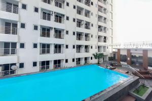 メダンにあるSimply Look Studio Apartment at Mansyur Residence By Travelioの建物の前のプール