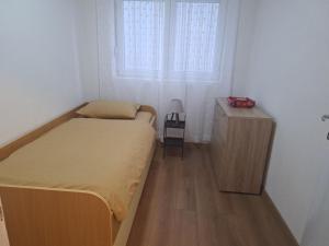 a small bedroom with a bed and a wooden cabinet at Neda Guesthouse in Žabljak +1 photo