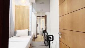 PampangにあるBest Price 2BR Apartment Vida View Makassar By Travelioのベッドと鏡のある小さな部屋 +19枚の写真