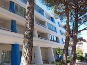 an apartment building with two trees in front of it at Miggle-Moo-Sea in Argelès-sur-Mer