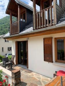 a house with a balcony and a patio at Villa du Lys Bagnères de Luchon in Luchon