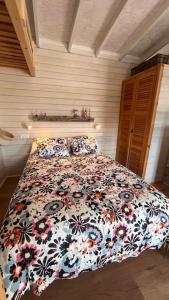 a bedroom with a bed with a floral comforter at La Casita in Cuartillos +17 photos