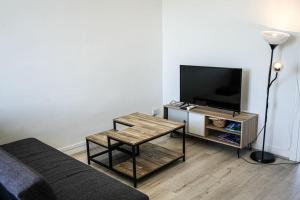 een woonkamer met een flatscreen-tv en een tafel bij F4 - La Maison de M Goéland - 4e etage in Le Havre