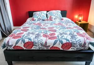 een bed met een kleurrijk dekbed en kussens erop bij F4 - La Maison de M Goéland - 4e etage in Le Havre