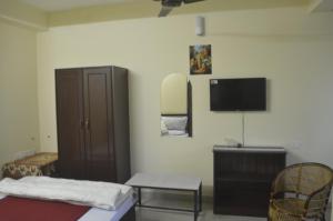 a bedroom with a bed and a tv on the wall at Green Castle Residency in Nedukandam