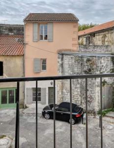 ein schwarzes Auto, das vor einem Gebäude geparkt ist in der Unterkunft Le Presbytère de Maître Jacques in Arles