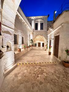 an empty courtyard of a building with a large building at Hira Cave Hotel in Göreme