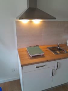 a kitchen with a counter with a sink and a stove at Villas Camargo.suites in Camargo