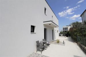 un patio avec des chaises et une table à côté d'un bâtiment dans l'établissement House Andrej, Entire semi-detached house with a terrace, parking, 400 m from beach, à Bašanija