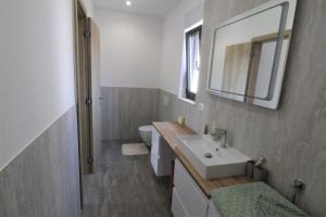 une salle de bain avec un lavabo, des toilettes et un miroir dans l'établissement House Andrej, Entire semi-detached house with a terrace, parking, 400 m from beach, à Bašanija 30 autres photos