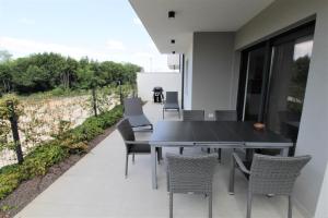 d'une table à manger et de chaises noires sur le balcon. dans l'établissement House Andrej, Entire semi-detached house with a terrace, parking, 400 m from beach, à Bašanija