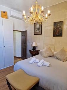 ein Schlafzimmer mit einem großen weißen Bett mit einem Kronleuchter in der Unterkunft Le Presbytère de Maître Jacques in Arles + 22 Fotos