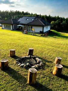 a group of tree stumps in front of a house at Siedlisko Błotnia in Mierzeszyn