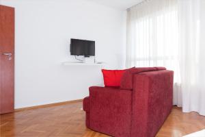 a red chair with a red pillow in a living room at Apartment Dream4you in Zagreb