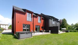 a red and black house with a yard at Posti villa 2 in Pärnu