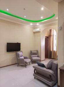 a waiting room with two chairs and a flat screen tv at Tatapartment in Tbilisi City