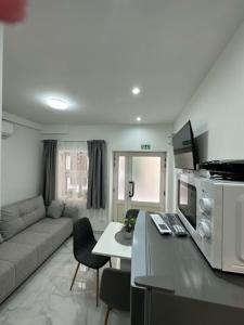 a kitchen and living room with a couch and a table at Apartmani Žaneta in Kaštela