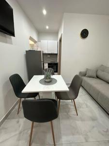a living room with a table and chairs and a couch at Apartmani Žaneta in Kaštela