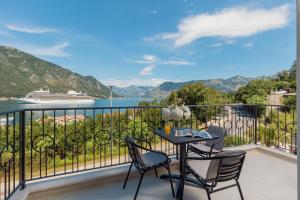a balcony with a table and chairs and a cruise ship at NM Palace Apartment in Kotor