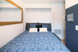 una camera da letto con un letto blu con due cuscini di Studio cosy coeur du Touquet proche plage - Wifi a Le Touquet-Paris-Plage