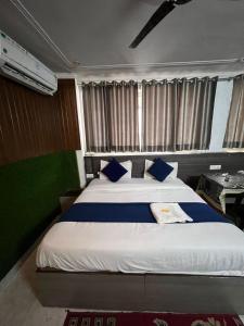 a bedroom with a large bed with blue pillows at Hotel devoy inn by namastexplorer in Rishīkesh