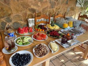 a table with many plates of fruit and vegetables at Villa Lorenzo in Cala Figuera