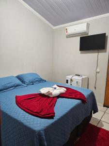 a bedroom with a red blanket on a bed at Pousada Anayh-Bom Jardim-Nobres in Estivado