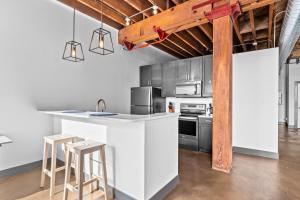 una cucina con bancone e alcuni sgabelli di Riverfront Loft-Parking-Gym-Deck-4I a Saint Louis