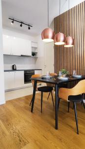 a kitchen and dining room with a black table and chairs at Wonderful Apartment near City Mall in Podgorica