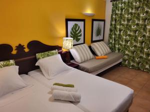 2 witte bedden in een kamer met een bank bij Au beau village studio vue nature in Sainte-Luce