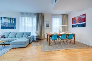 un soggiorno con un tavolo e un divano blu di Premium Penthouse E51 3 Schlafzimmer 2 Bäder 103qm PARKING FREE a Międzyzdroje
