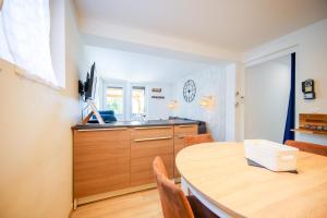 a kitchen with a wooden table and a counter top at Git chez BOUBET 1 in Arnos +9 photos