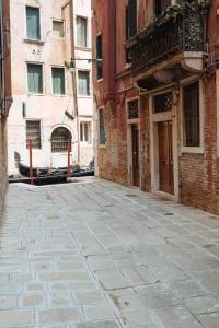 an empty street in an alley with buildings at Ca Del Gambero Canal View in Venice