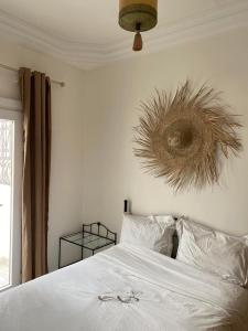 a bedroom with a white bed with a plant on the wall at Tarbouche on the Beach in Essaouira +17 photos