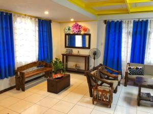 a living room with blue curtains and a couch at Kuyas Balay Baguio in Baguio
