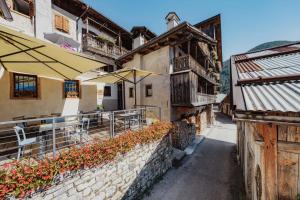 an outdoor cafe with tables and umbrellas next to a building at Locanda Nona Giò in Fornesighe