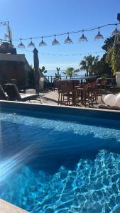 a swimming pool with a table and chairs next to the water at Les Alcyons in Le Lavandou