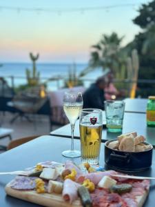 a table with a plate of food and a glass of wine at Les Alcyons in Le Lavandou +37 photos