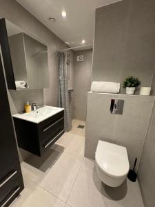 a bathroom with a white toilet and a sink at Lillestrøm home in Lillestrøm