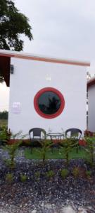 twee stoelen en een raam in een witte muur bij จันทร์ทิพย์คคำชะโนด 2 เฟท 2 in Ban Dung
