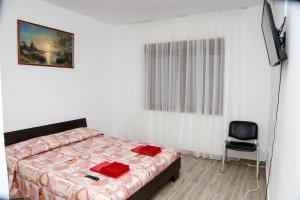 a bedroom with a bed and a television and a chair at Vila Giovanni in Orşova
