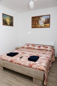 a bedroom with a large bed with two pillows on it at Vila Giovanni in Orşova