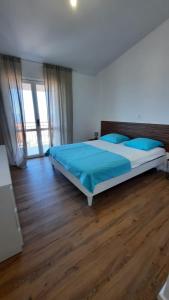 a bedroom with a bed with blue sheets and a wooden floor at Apartments Ruzica in Makarska