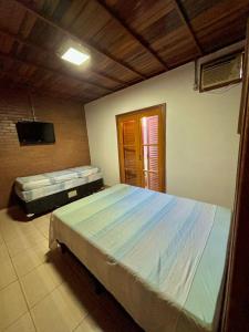 a bedroom with a large bed and a television at Casa ecológica temporada in Olímpia