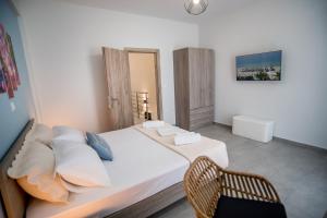 a bedroom with a white bed and a chair at Terra Kotta 2 in Vrachos